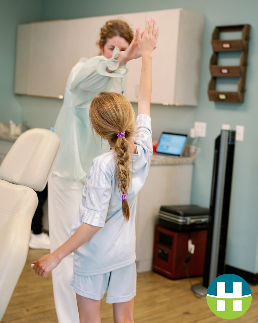 Young patient and team member high-fiving during a fun, engaging orthodontic appointment at Hamada Orthodontics